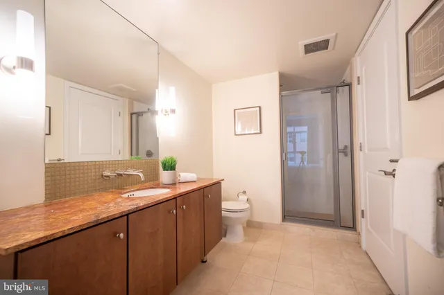 a bathroom with a granite countertop sink toilet and shower