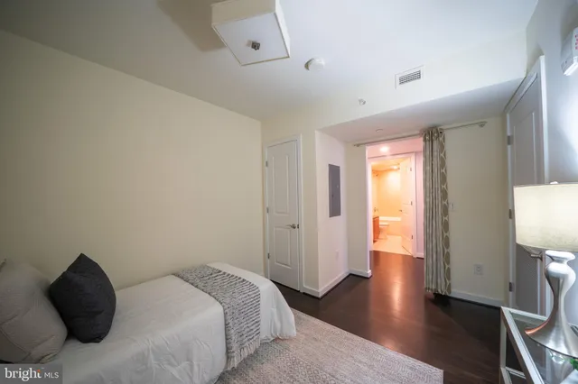a bedroom with a bed and wooden floor