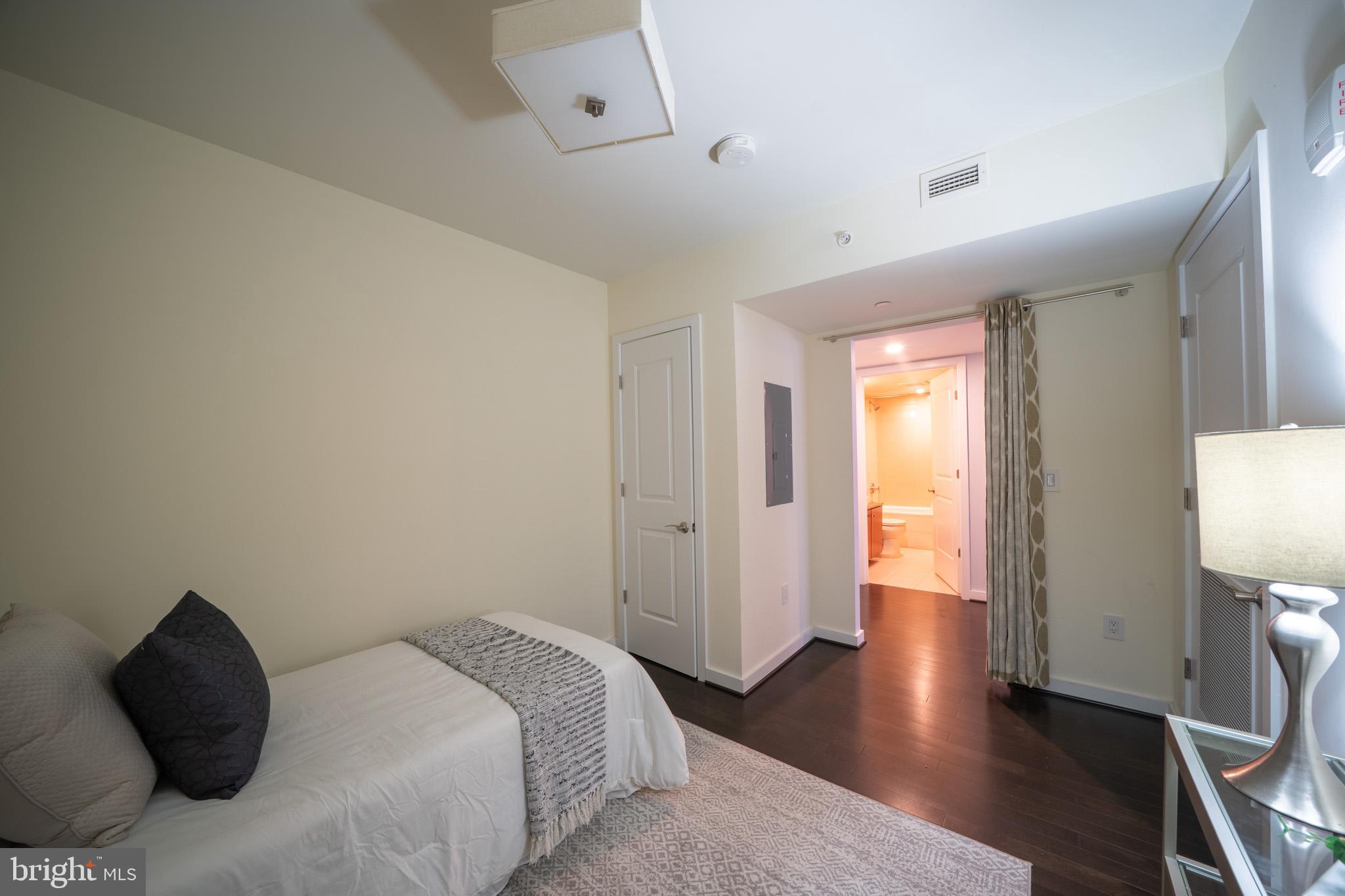 1025 First Street Southeast, Unit 611 Washington, DC 20003 - Photo 17 of 36 a bedroom with a bed and wooden floor