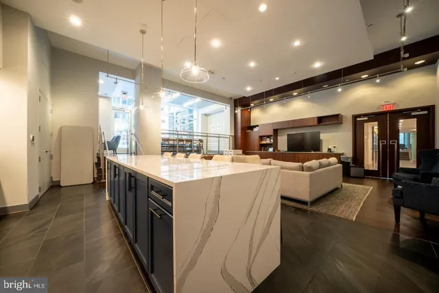 a large kitchen with kitchen island a island a sink a counter top space and living room view