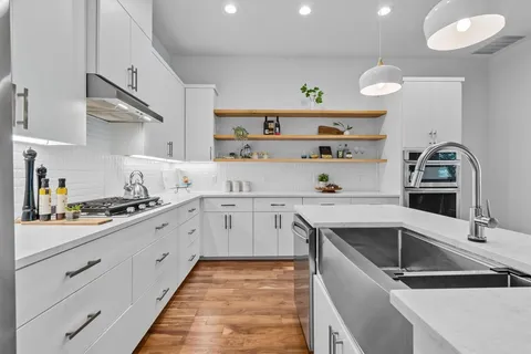 a large kitchen with lots of counter space a sink appliances and dining table
