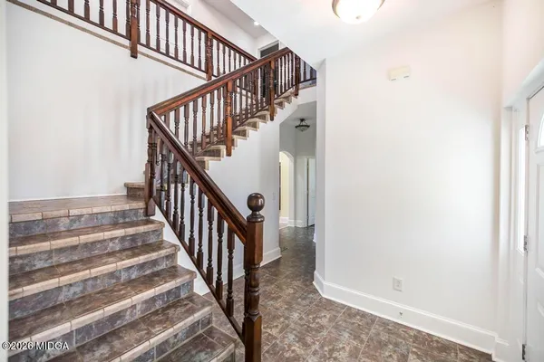 a view of a hallway with wooden floor and staircase