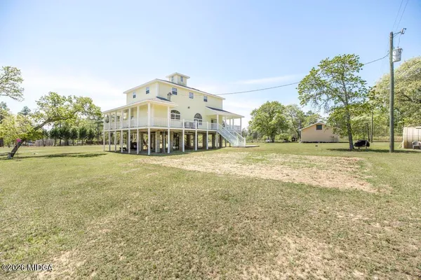 a view of a big room with a big yard and large trees