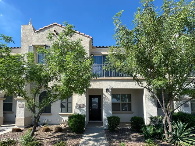 a front view of a house with plants and trees