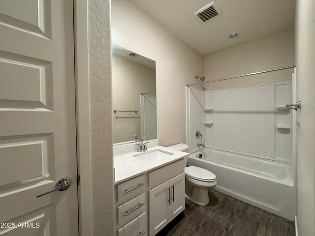 a bathroom with a double vanity sink toilet mirror and shower
