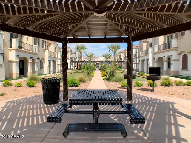 a view of a patio with table and chairs potted plants and large tree