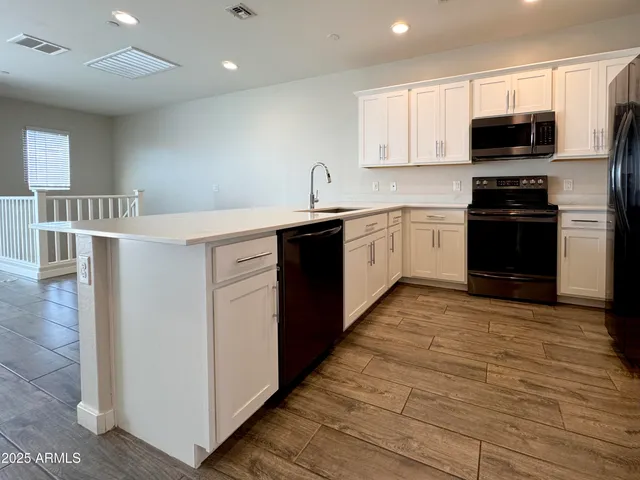 a kitchen with stainless steel appliances a refrigerator sink and microwave