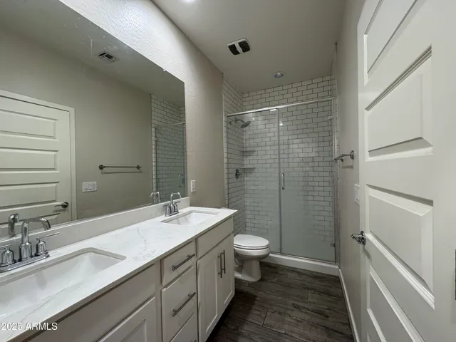 a bathroom with a double vanity sink toilet and shower