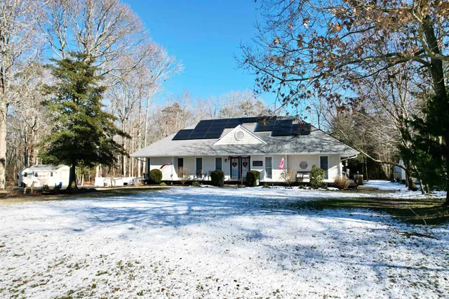 a front view of a house with a garden and trees