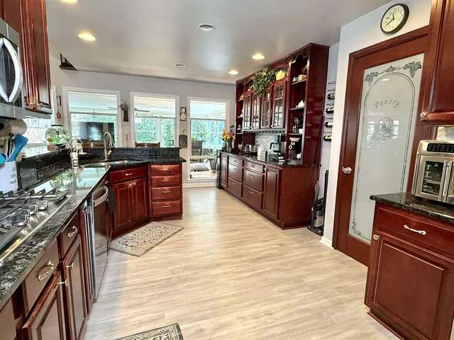 a kitchen with stainless steel appliances granite countertop a refrigerator sink and cabinets