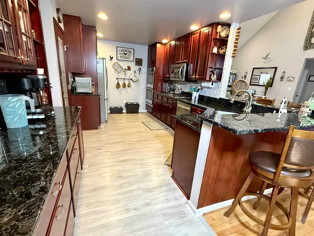 a view of a dining room with furniture a chandelier and wooden floor