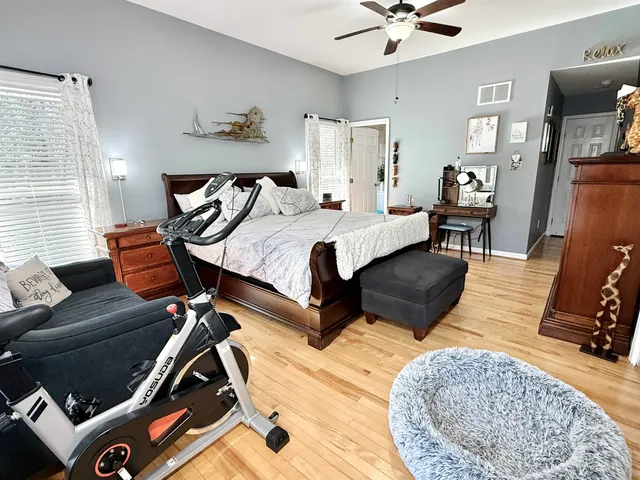 a spacious bedroom with a bed and wooden floor