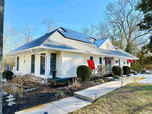 a view of a white house with a chairs in a patio
