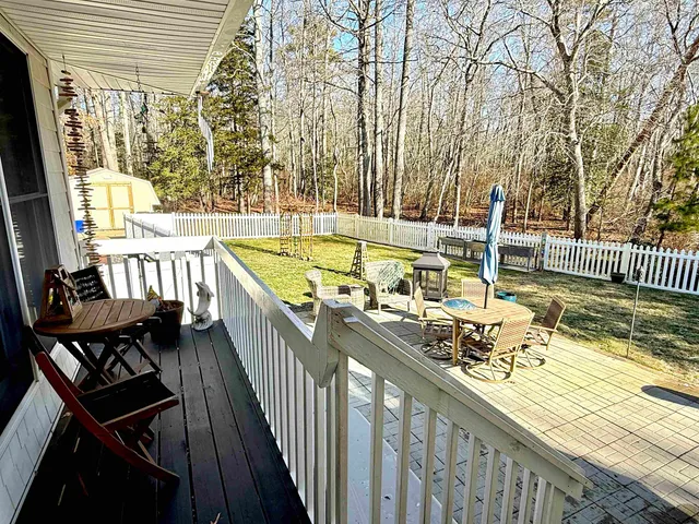 a view of a swimming pool with chairs and floor to ceiling window