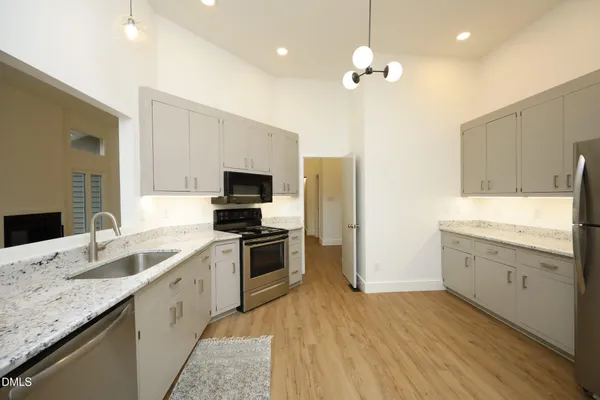a large kitchen with granite countertop a sink stainless steel appliances and cabinets