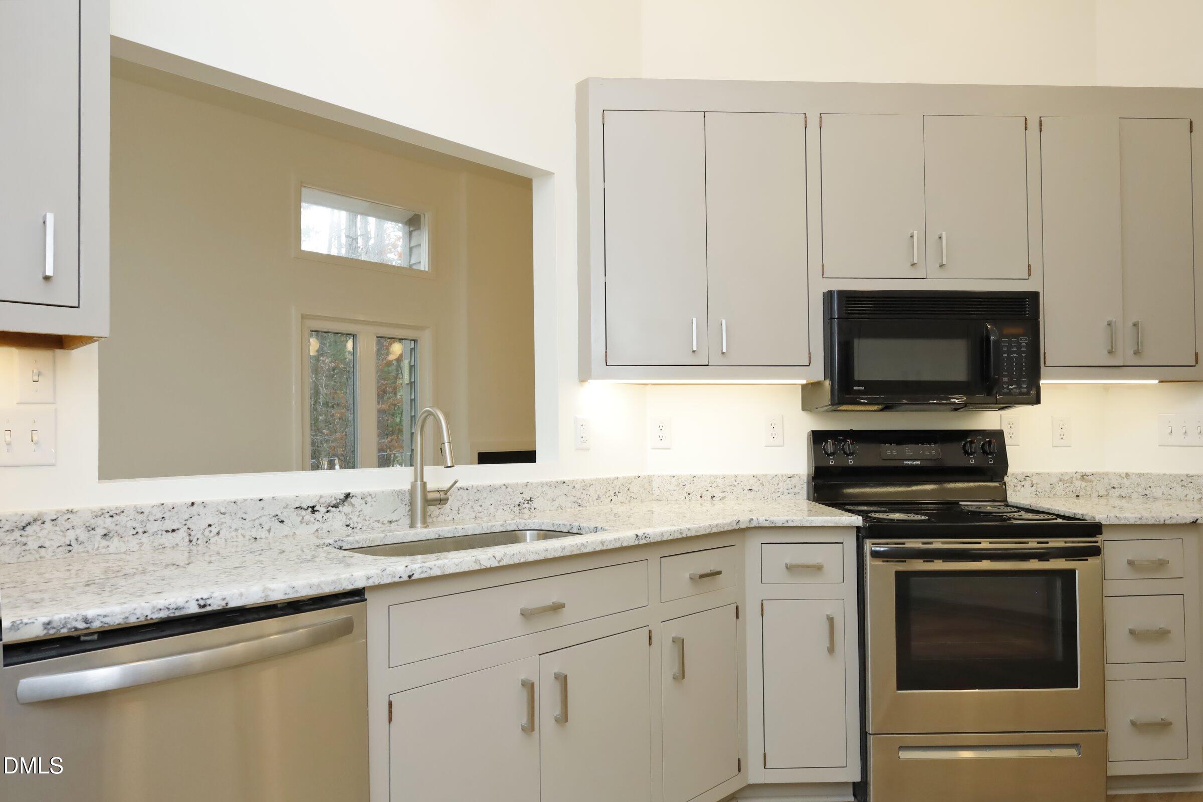 237 Glen Eden Road Durham, NC 27713 - Photo 12 of 37 a kitchen with granite countertop white cabinets and stainless steel appliances