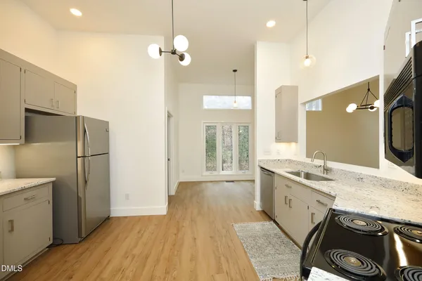 a spacious bathroom with a granite countertop sink a toilet a mirror and shower