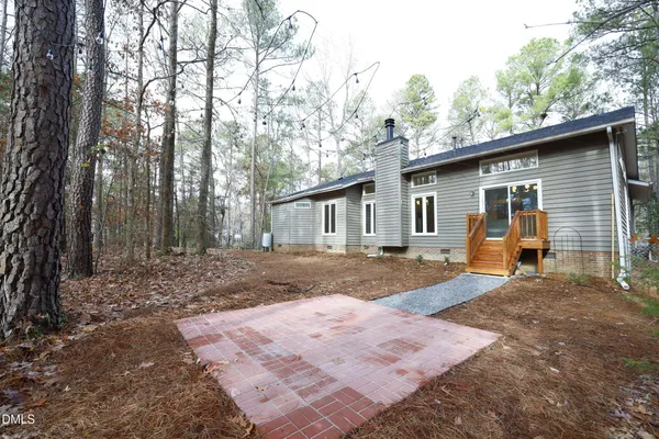 a view of a house with a yard and tree