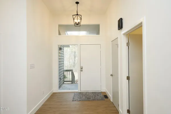 a view of a hallway with wooden floor and a bathroom