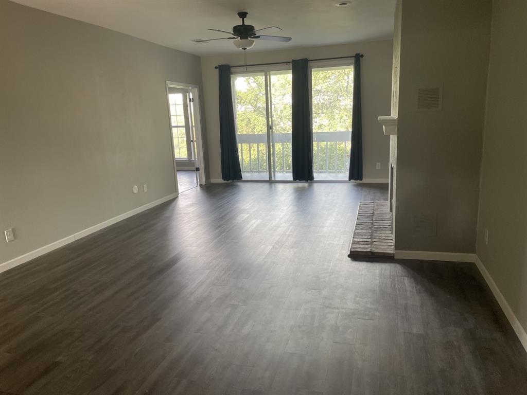 5310 Keller Springs Road, Unit 132 Dallas, TX 75248 - Photo 6 of 11 an empty room with wooden floor and windows