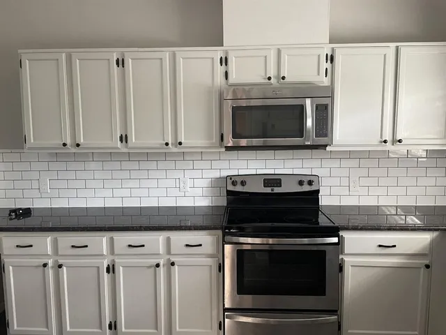 a kitchen with cabinets and stainless steel appliances