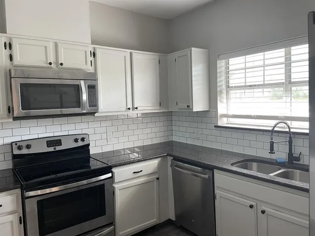 a kitchen with appliances a sink and a microwave