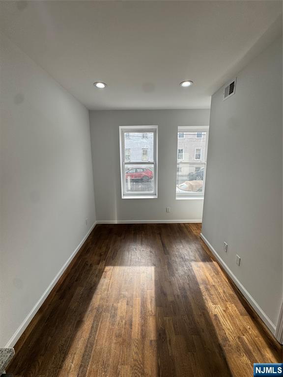196 Malvern Street, Unit 1 Newark, NJ 07105 - Photo 5 of 16 an empty room with wooden floor and windows