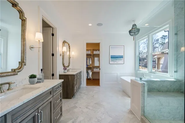 a spacious bathroom with a tub sink and mirror