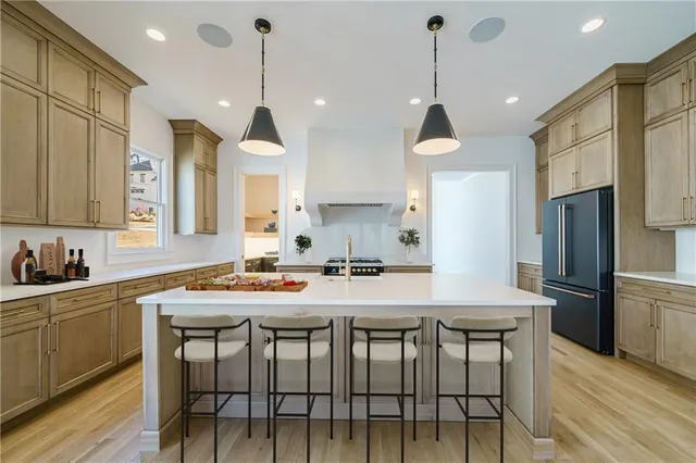 a kitchen with sink a refrigerator and chairs