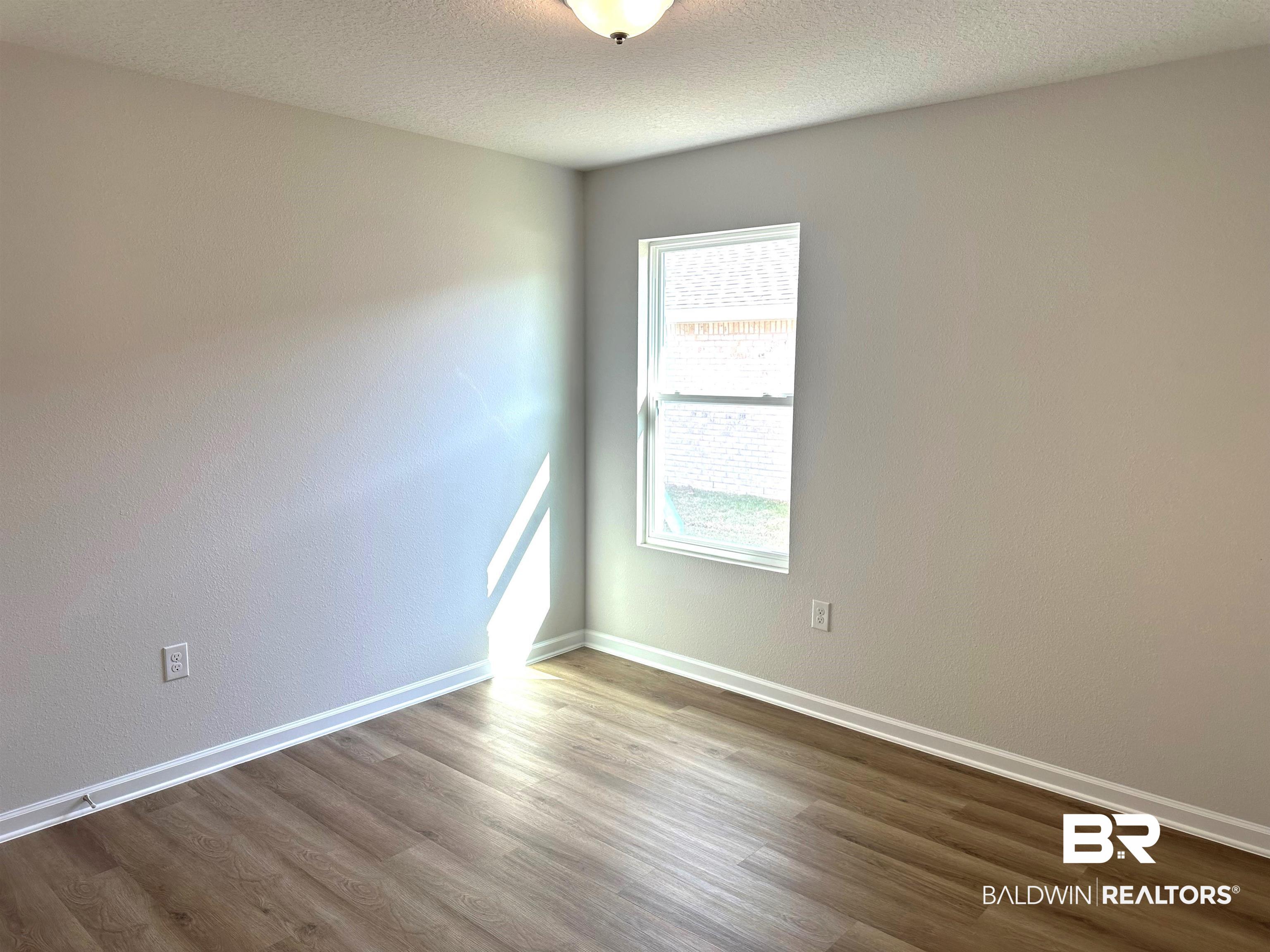 1234 Hayward Loop Foley, AL 36535 - Photo 18 of 31 Spare room with wood-type flooring and a textured ceiling