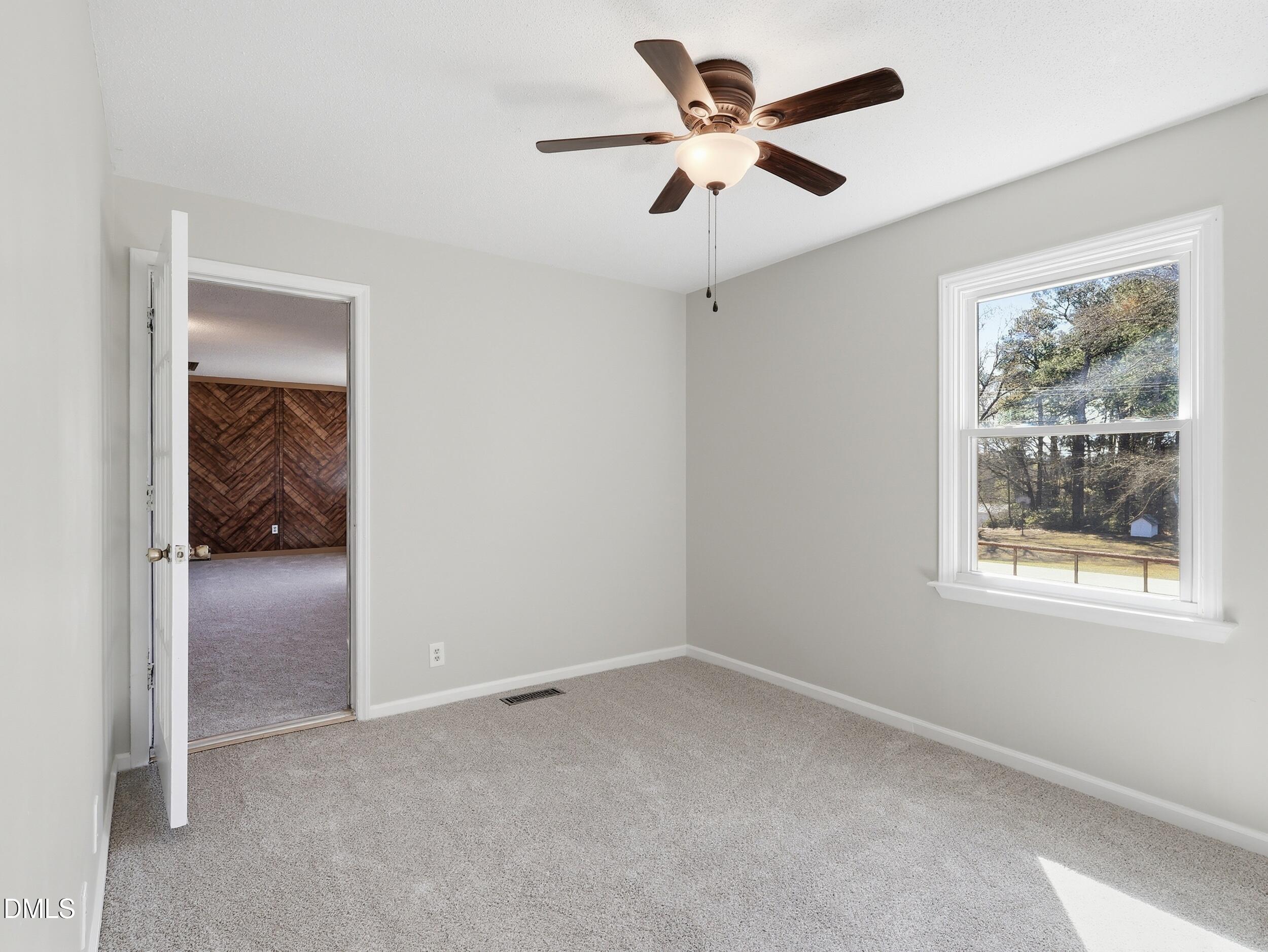 19405 Highway 210 Angier, NC 27501 - Photo 25 of 49 an empty room with a ceiling fan and a window
