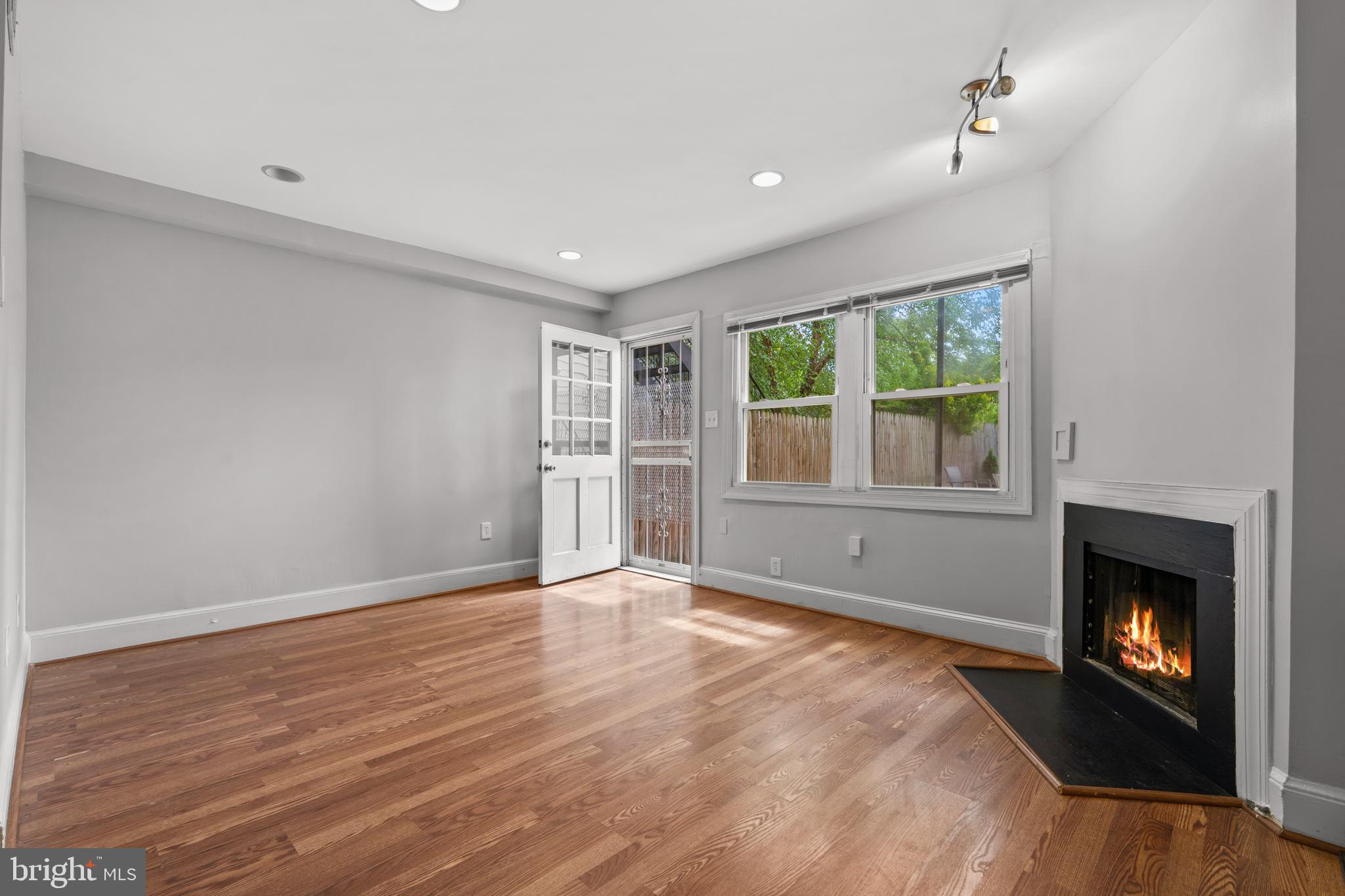 a view of an empty room with a window and fireplace