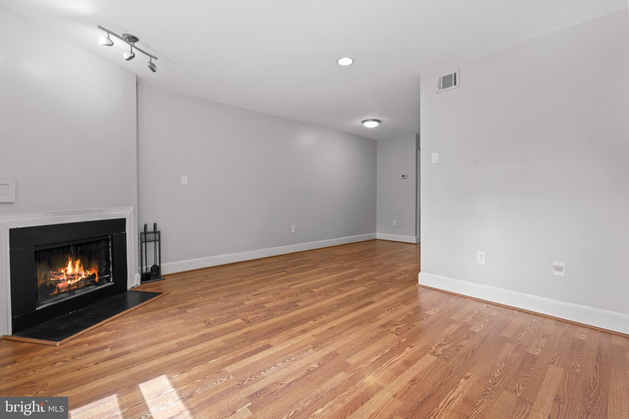 1815 East Capitol Street Southeast, Unit 1 Washington, DC 20003 - Photo 13 of 19 a view of an empty room with wooden floor fireplace and a window