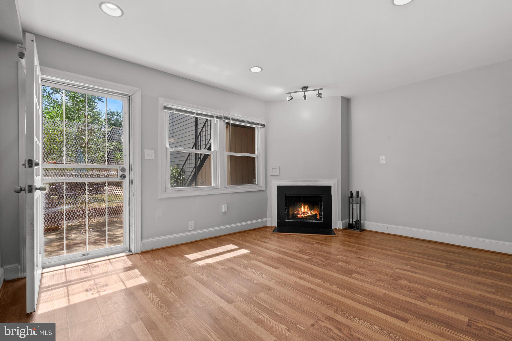 1815 East Capitol Street Southeast, Unit 1 Washington, DC 20003 - Photo 14 of 19 an empty room with windows a fireplace and wooden floor