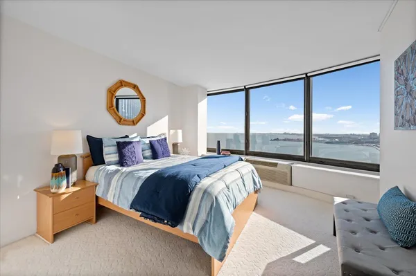 a bedroom with a bed and a large window