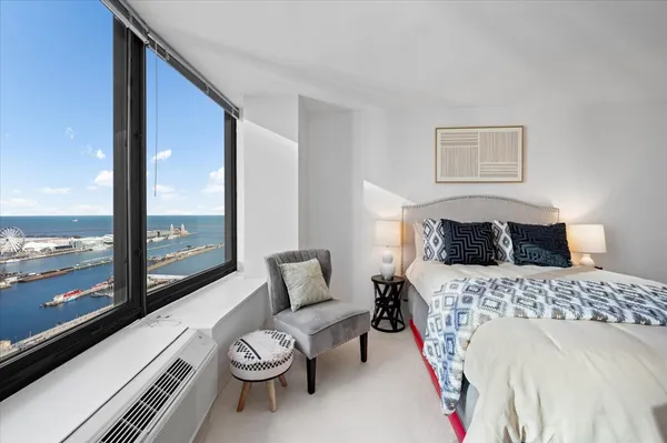 a bedroom with a bed and a large window with outer view