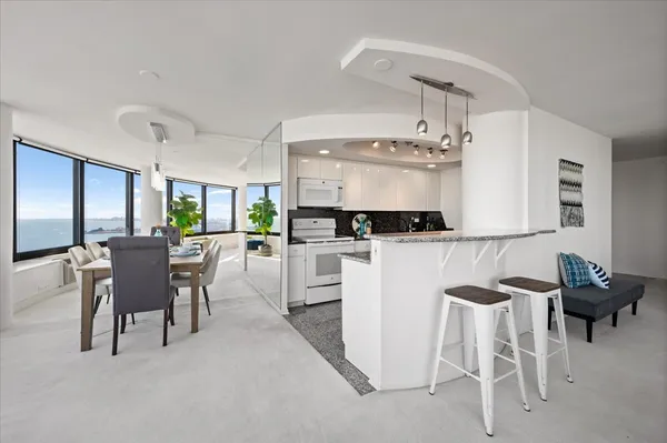a kitchen with granite countertop white cabinets and stainless steel appliances