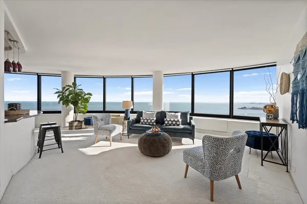a living room with furniture a chandelier and a floor to ceiling window