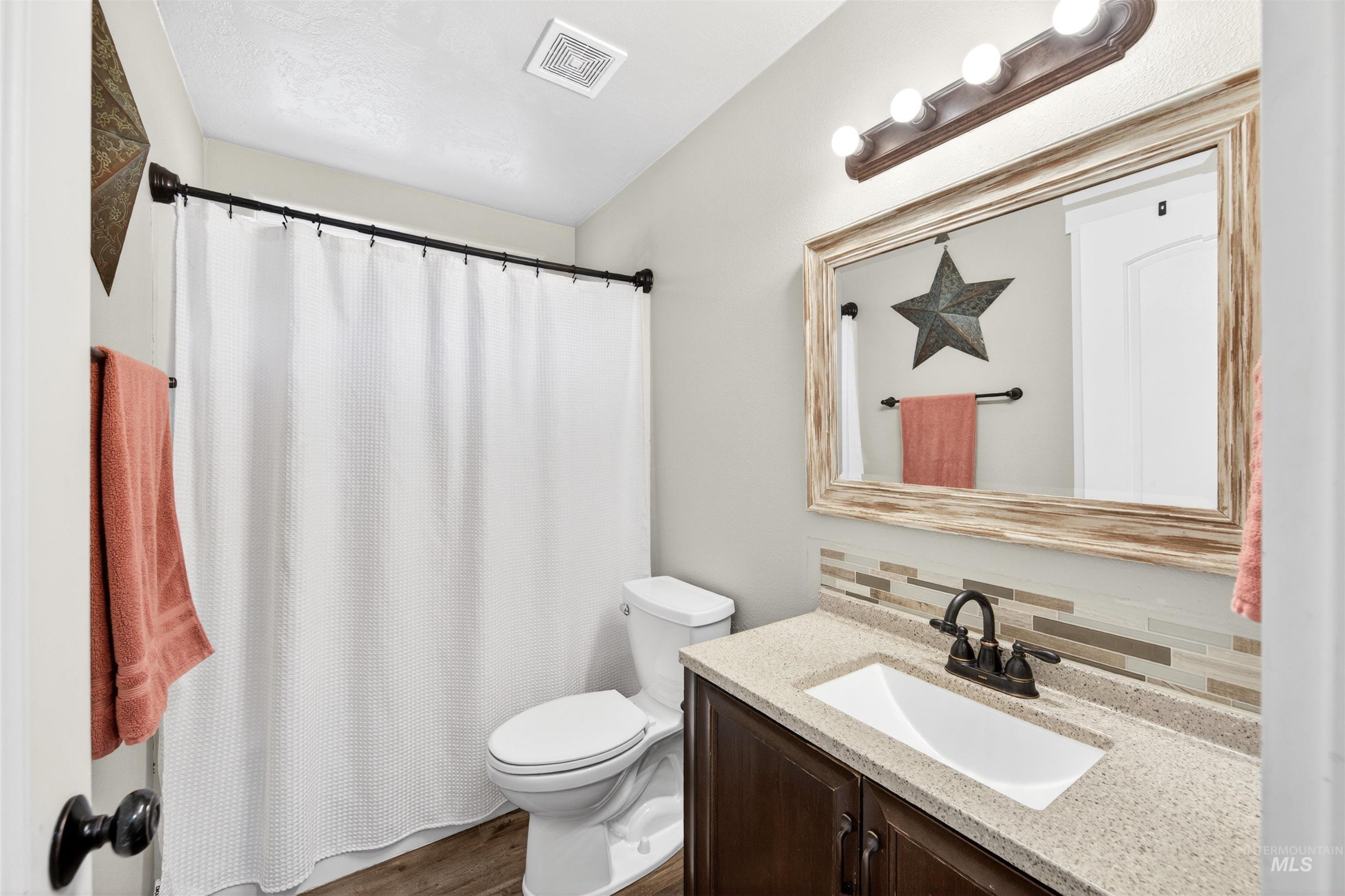 4 Round Up Circle Boise, ID 83716 - Photo 31 of 47 Vanity with a light-toned countertop, dark wood-finish cabinetry, and a tile backsplash