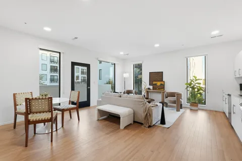 a living room with furniture flat screen tv and wooden floor