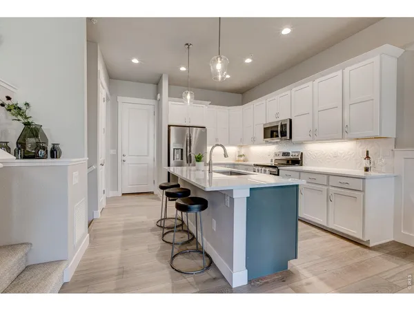 a kitchen with counter top space a sink and appliances