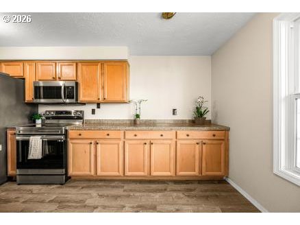 8496 Southwest Mohawk Street Tualatin, OR 97062 - Photo 13 of 39 a kitchen with stainless steel appliances granite countertop a stove a sink and a microwave