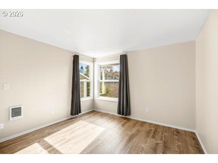 8496 Southwest Mohawk Street Tualatin, OR 97062 - Photo 21 of 39 a view of an empty room with wooden floor and a window