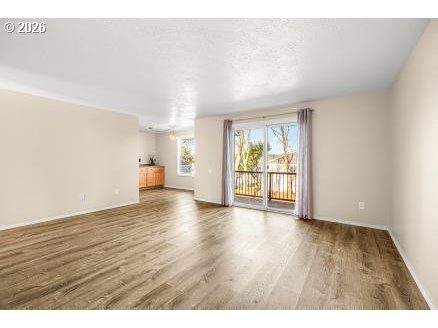 8496 Southwest Mohawk Street Tualatin, OR 97062 - Photo 8 of 39 a view of an empty room with wooden floor and a window