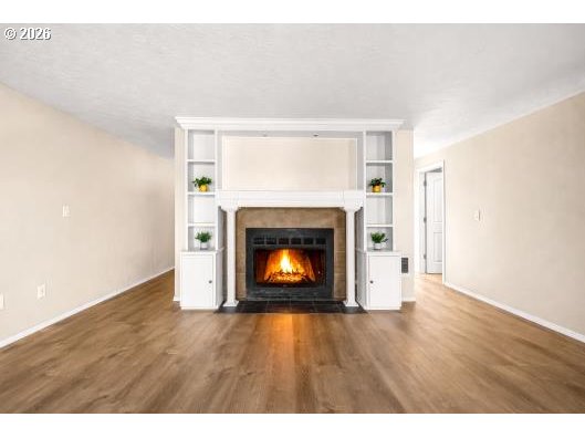 8496 Southwest Mohawk Street Tualatin, OR 97062 - Photo 10 of 39 a view of an empty room with wooden floor fireplace and a window