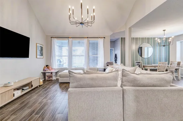a living room with furniture a flat screen tv and a large window