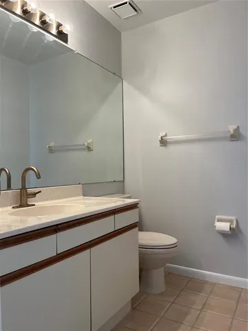 a bathroom with a granite countertop sink a toilet and a mirror