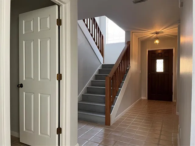 a view of a hallway with staircase and white walls