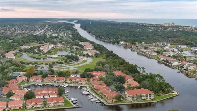 an aerial view of residential houses with outdoor space and lake view