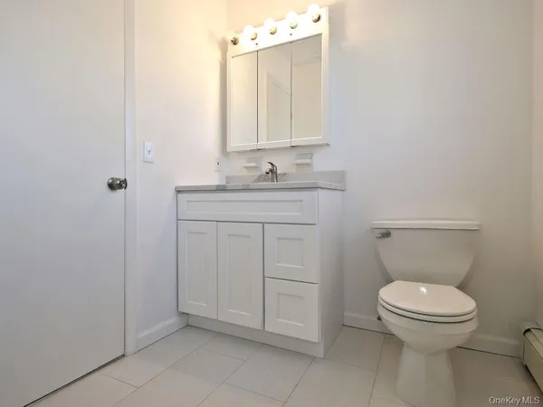 a view of an empty room with wooden floor and closet